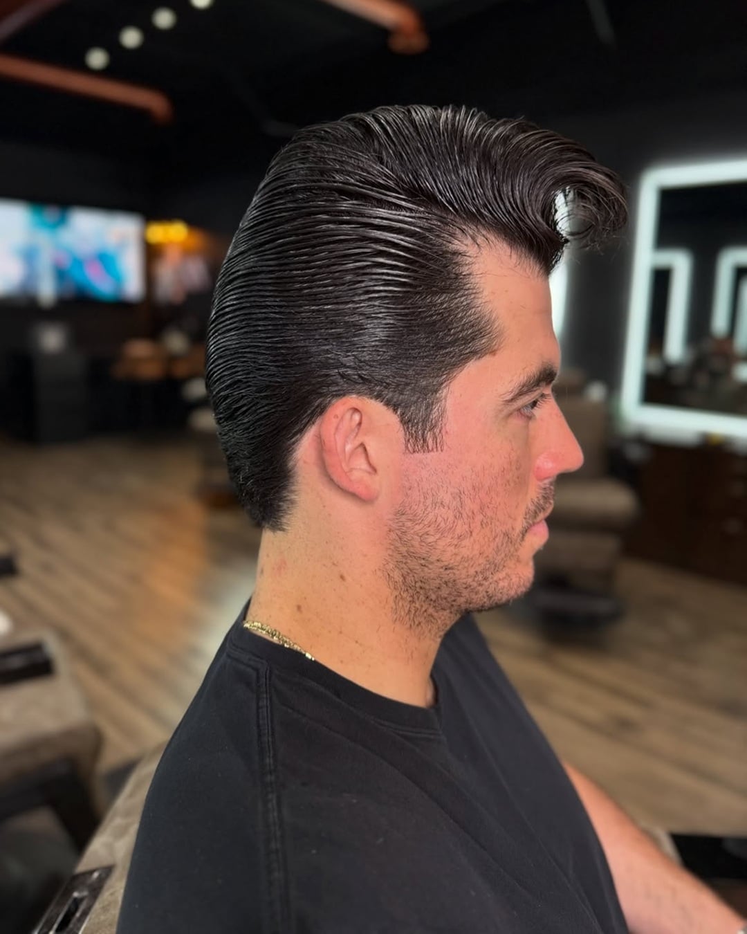 1940s voluminous pompadour haircut with slicked-back sides and a classic forward quiff