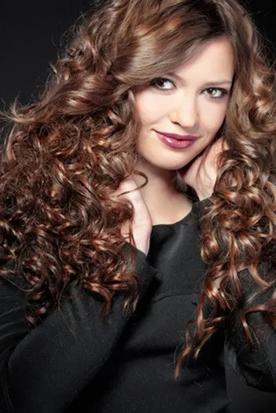 Portrait of young beautiful woman with long curly volume hair