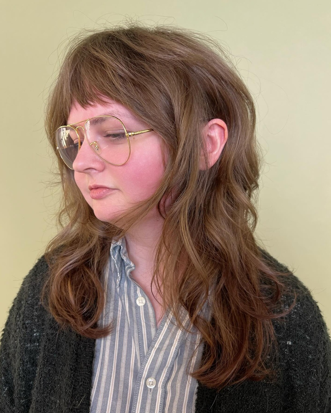 long retro 60s shag haircut with short choppy micro bangs and heavily layered face-framing texture