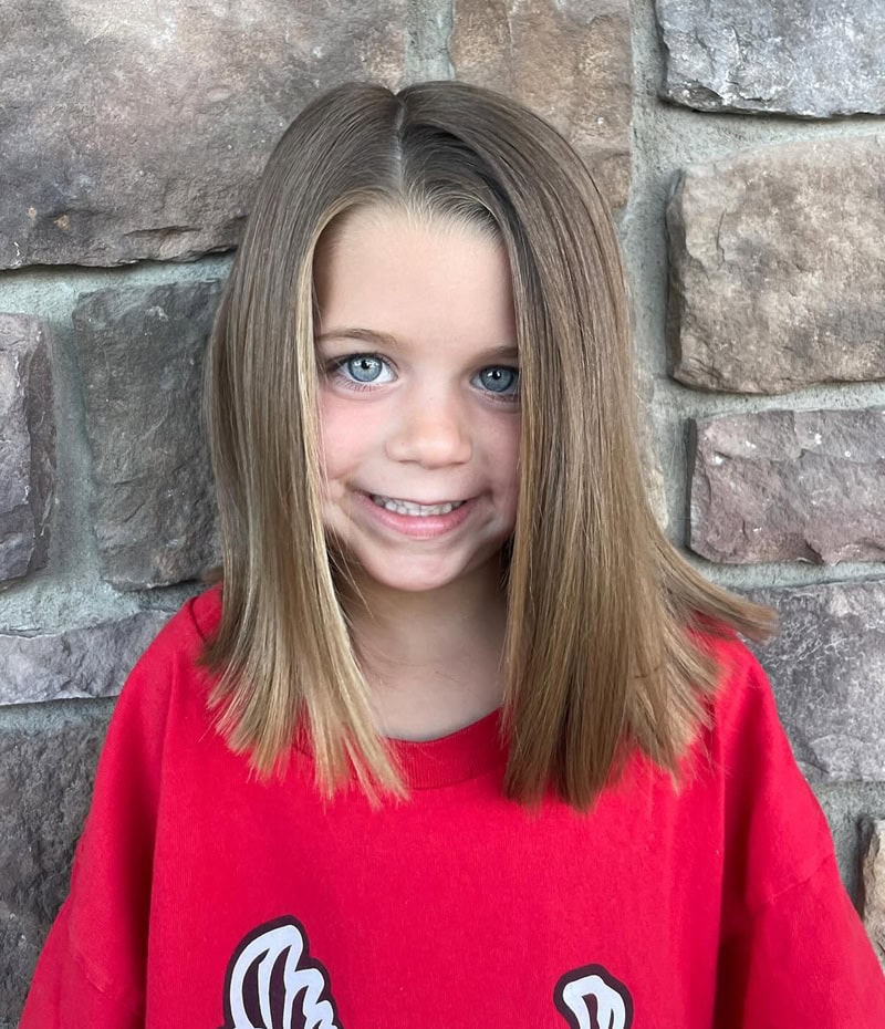 9 year old girl with a middle-parted, sleek long bob haircut
