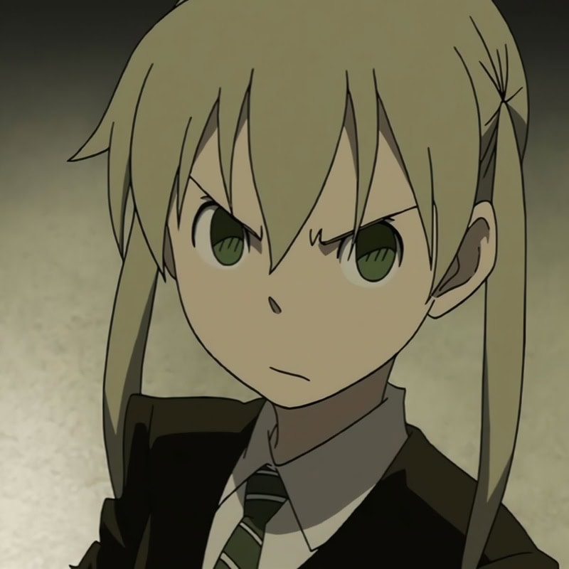 Maka Albarn with sandy ash-blonde hair tied into thin, low pigtails framing her face with choppy bangs