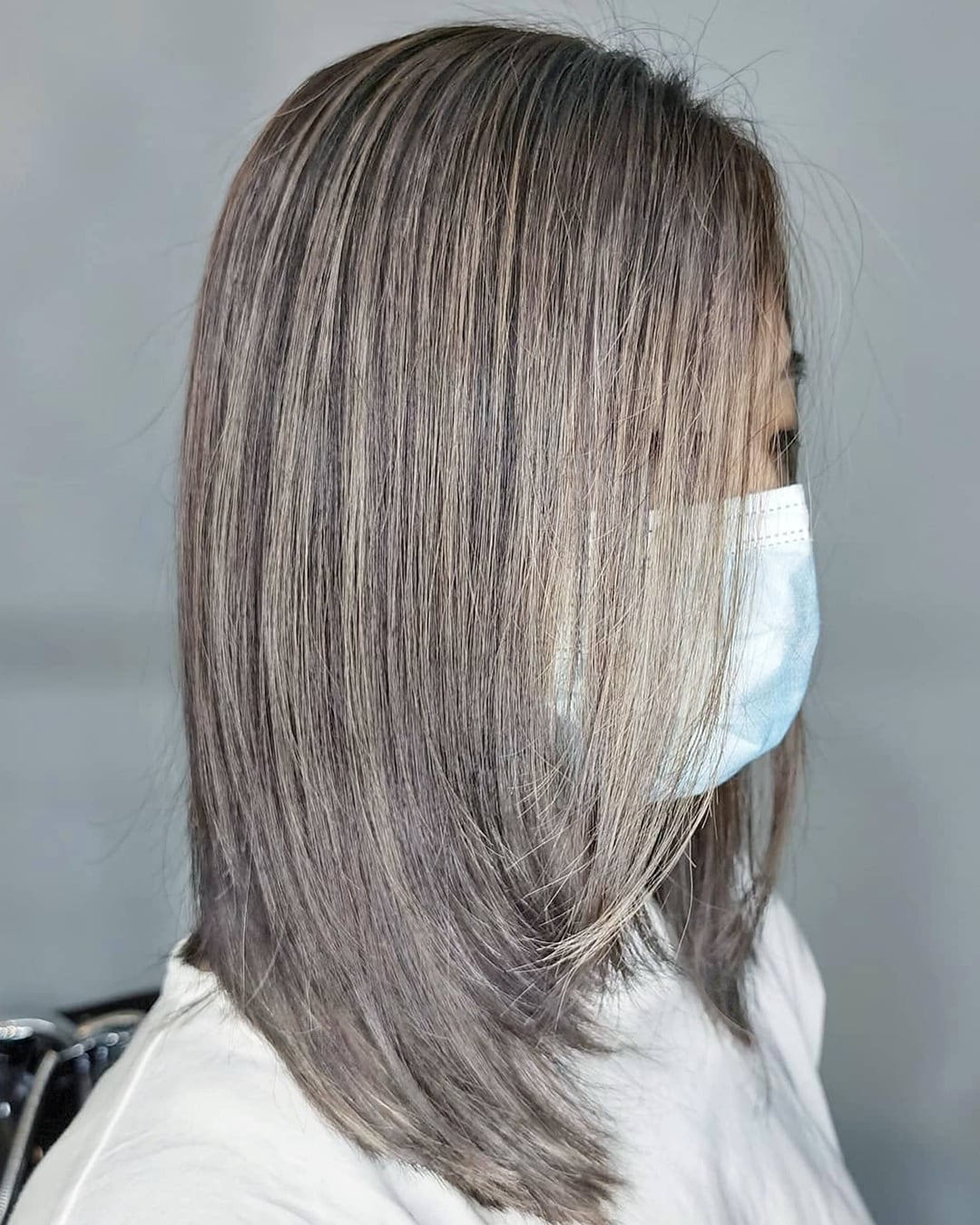 Straight shoulder length dark hair with subtle ash beige highlights on Asian hair