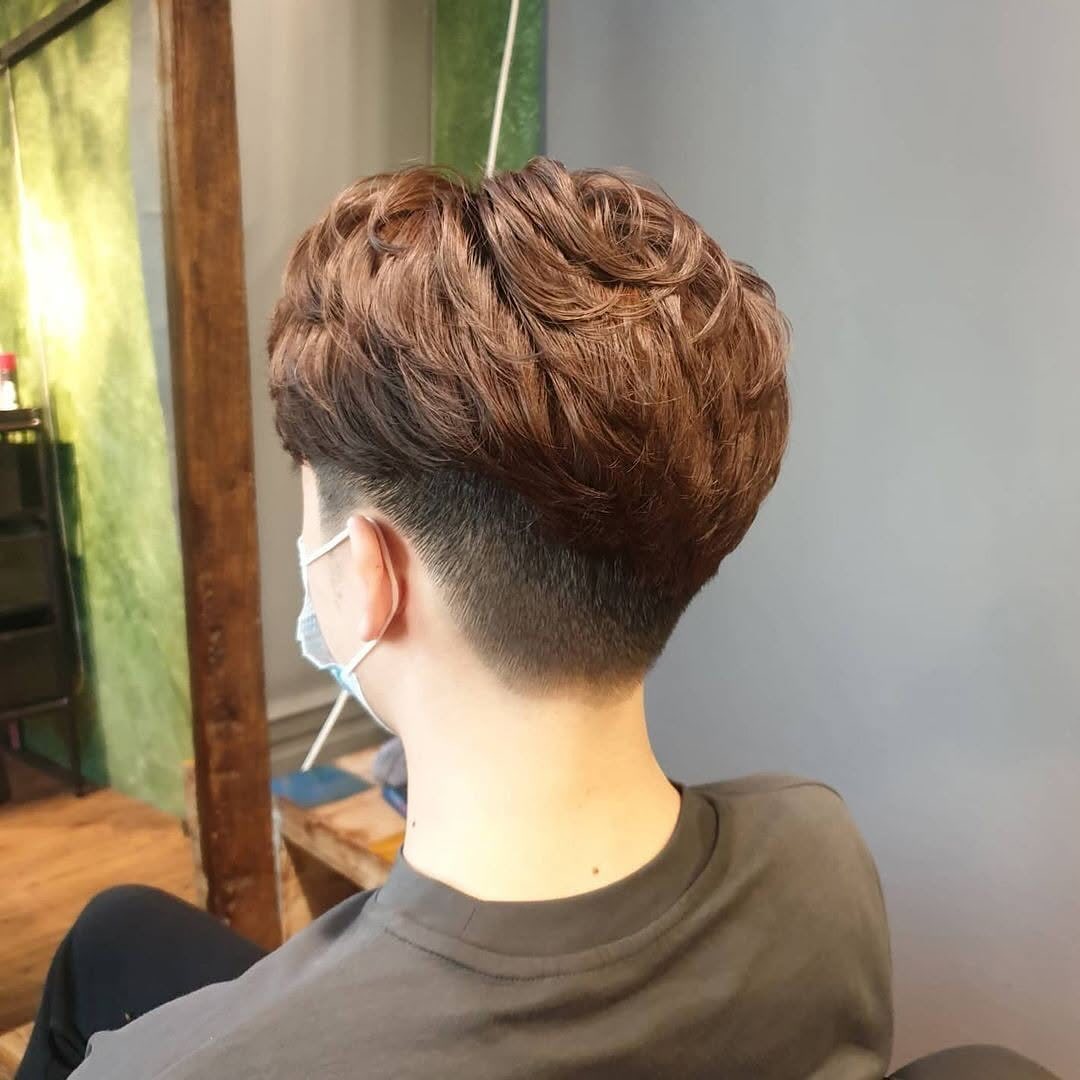 Brown Asian two-block haircut with textured layers and a tapered undercut nape