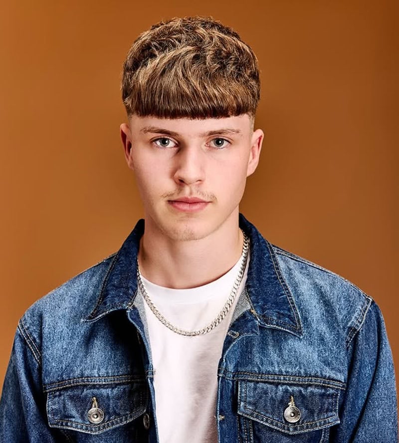 blonde man with a heavy, textured French crop and thick fringe