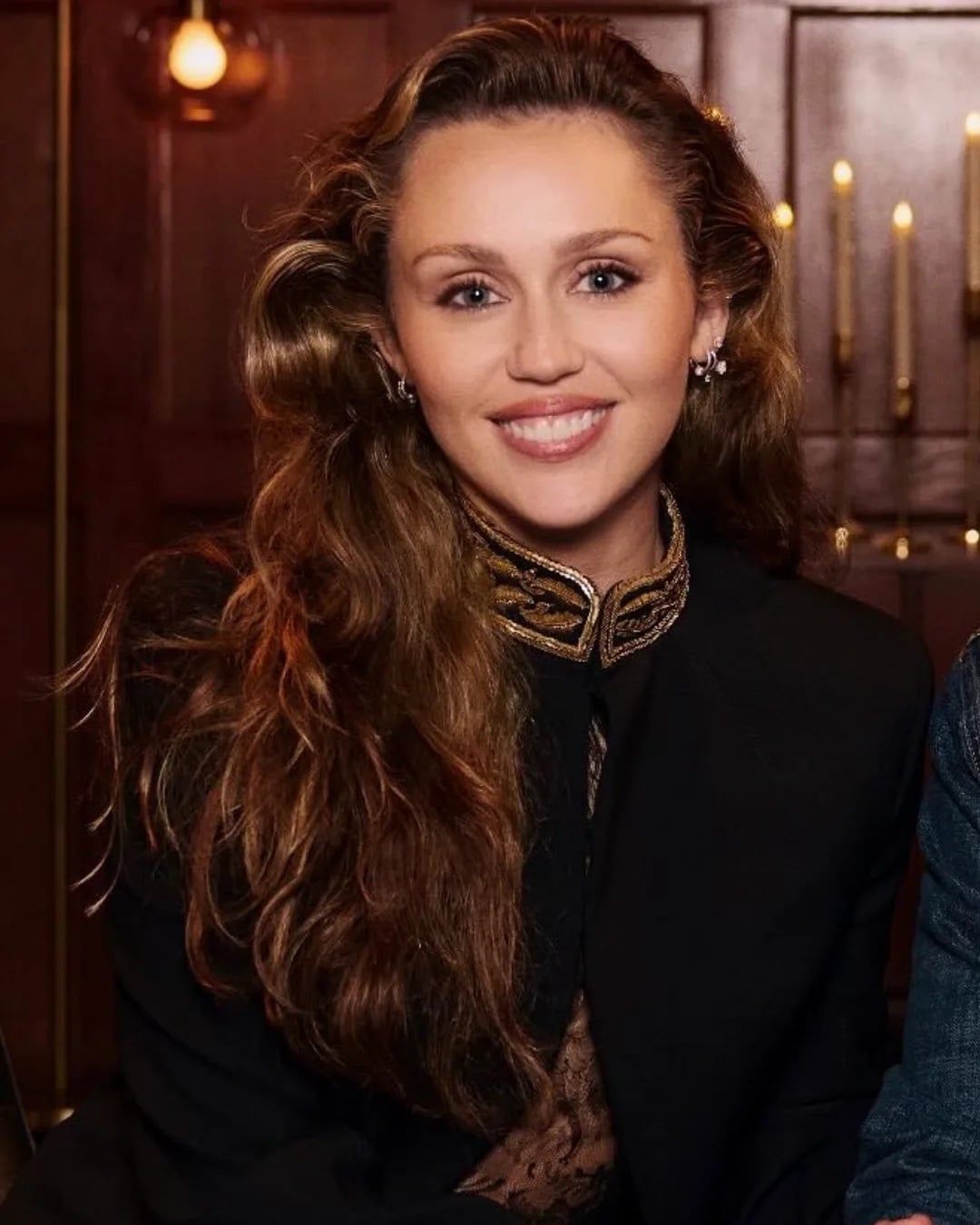 Actress Miley Cyrus with long brown hair styled in voluminous, soft loose waves