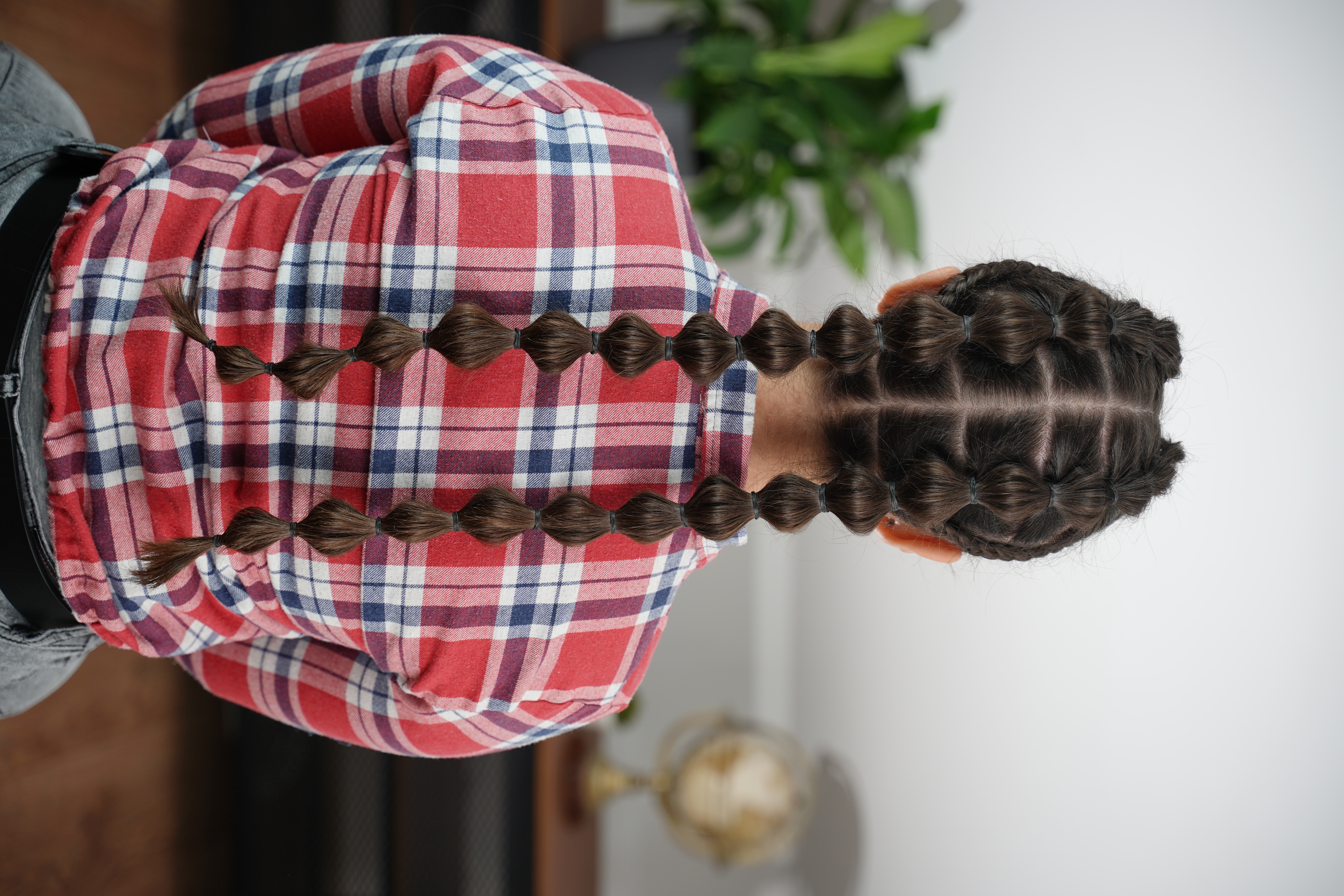 Back view of the finished double bubble braid pigtails with even bubbles and lace braid detail on both sides.