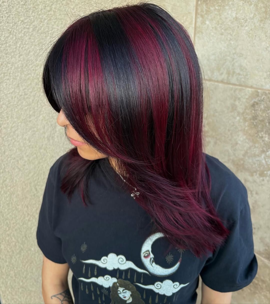 Medium straight dark Asian hair styled with chunky burgundy highlights