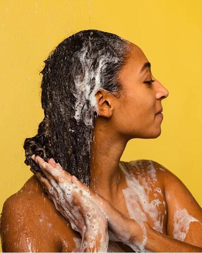 Woman co-washing hair with conditioner