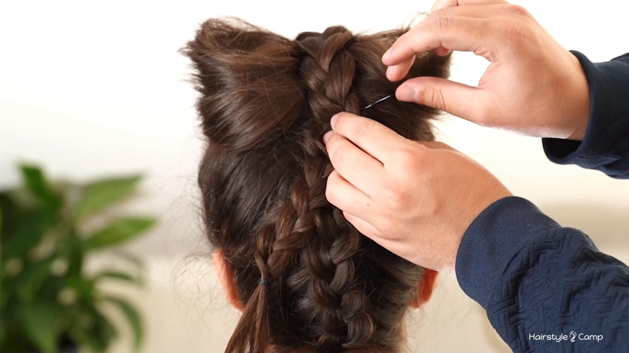Braided front section brought back over the bow loops and being pinned over the braid at the back.
