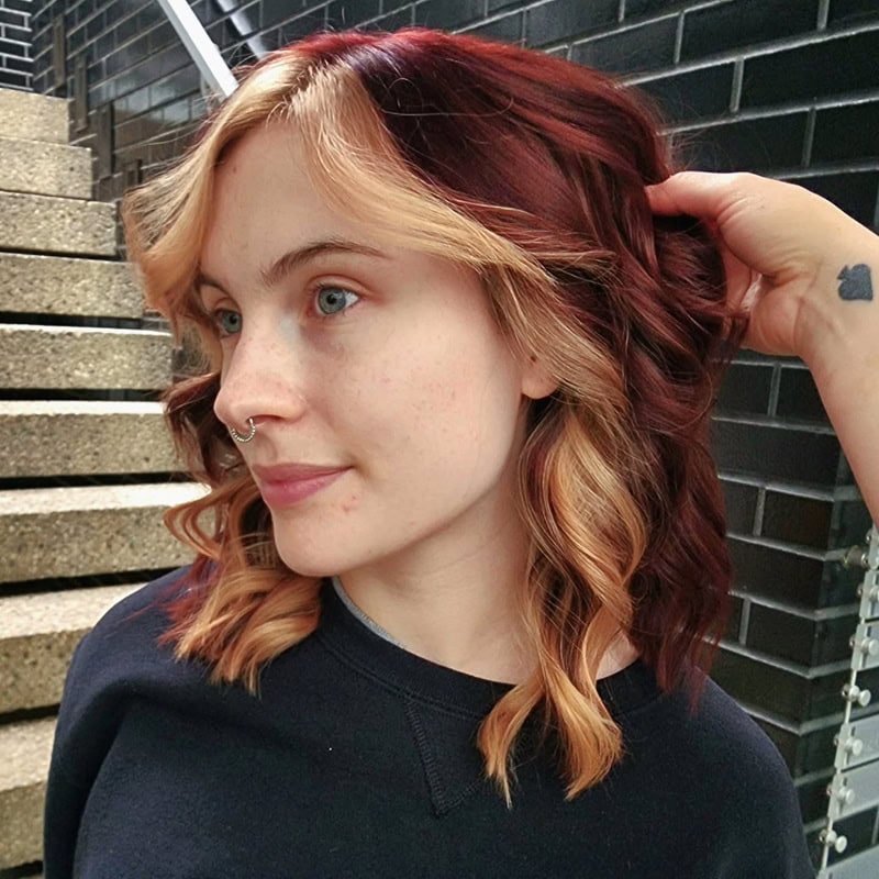 Wavy dark auburn hair with chunky blonde front highlights
