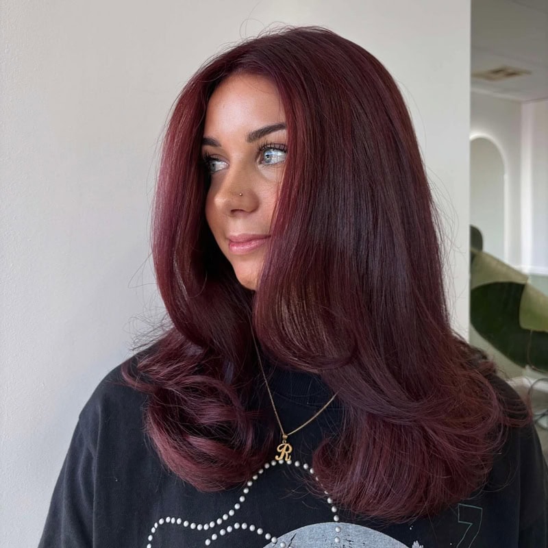 long, voluminous cherry cola hair with soft, face-framing curls