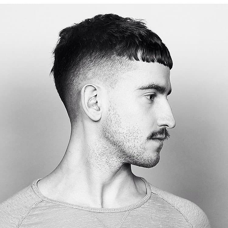 Side profile of a French crop fade haircut with a straight fringe concealing a thinning hairline