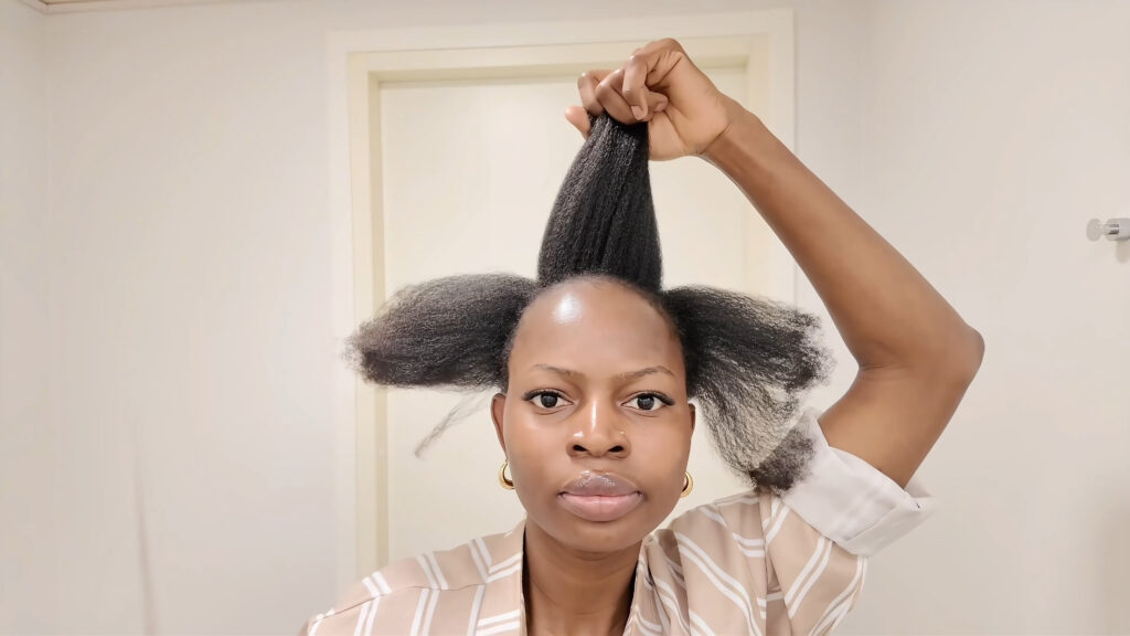 The stylist holds the center front section up after parting the front hair into three sections.