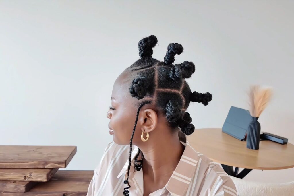 Bantu knot hairstyle with curved parts, raised knots, side braids, and coiled ends, recreated by Adeola Rebecca