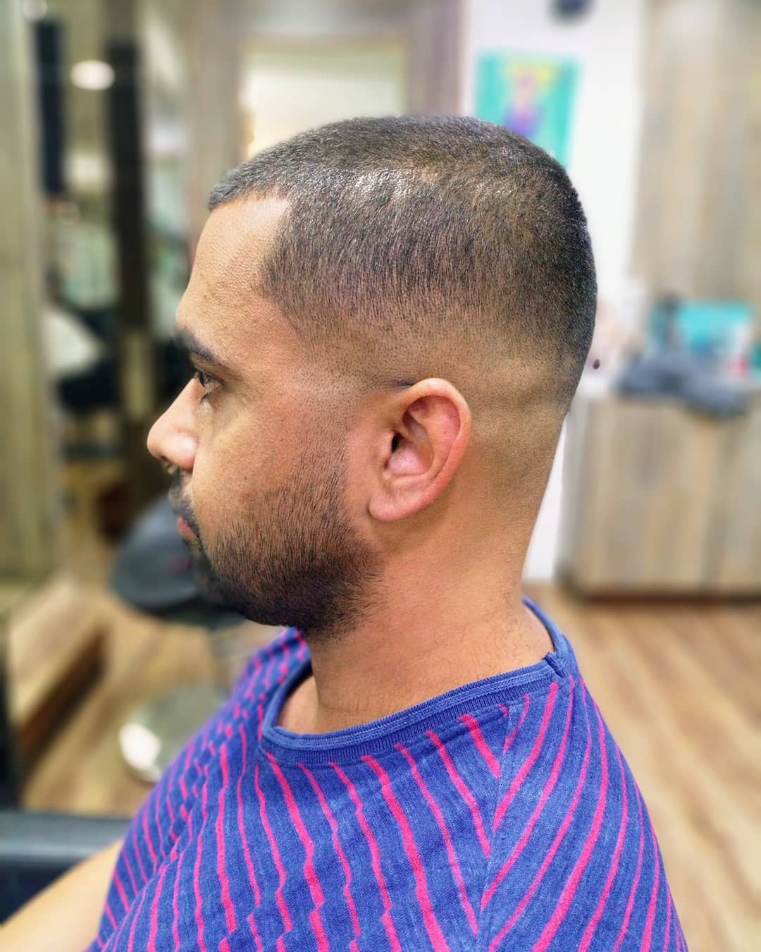 Indian guy with short buzz cut, high fade, and short stubble beard