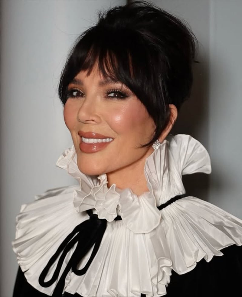 Kris Jenner wearing an elegant black updo with wispy bangs