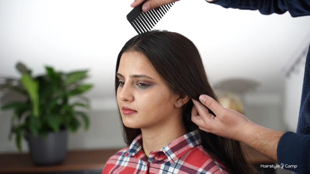 Hair being divided into a clean middle part before starting the bubble pigtails and lace braids.