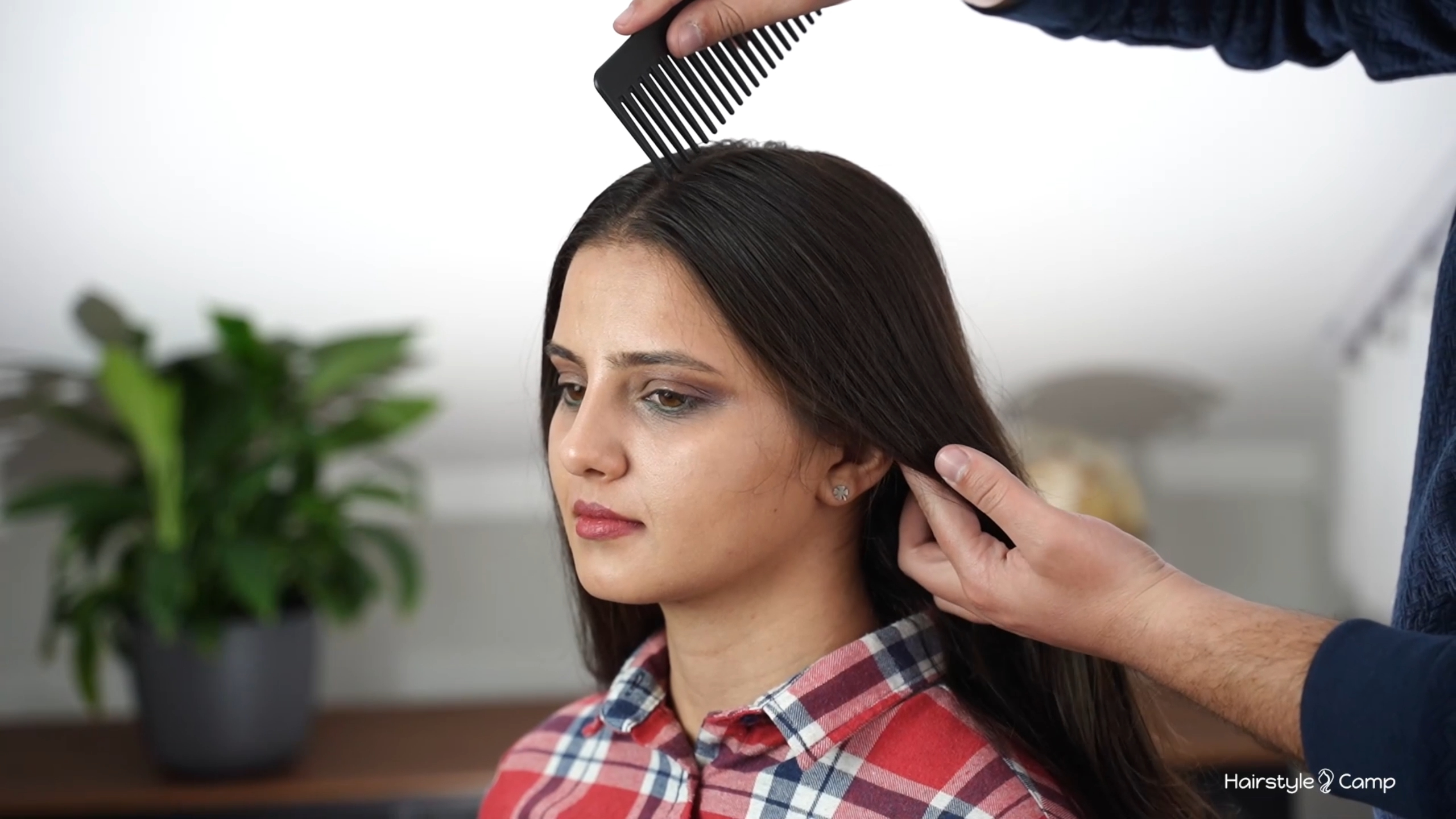 Hair being divided into a clean middle part before starting the bubble pigtails and lace braids.