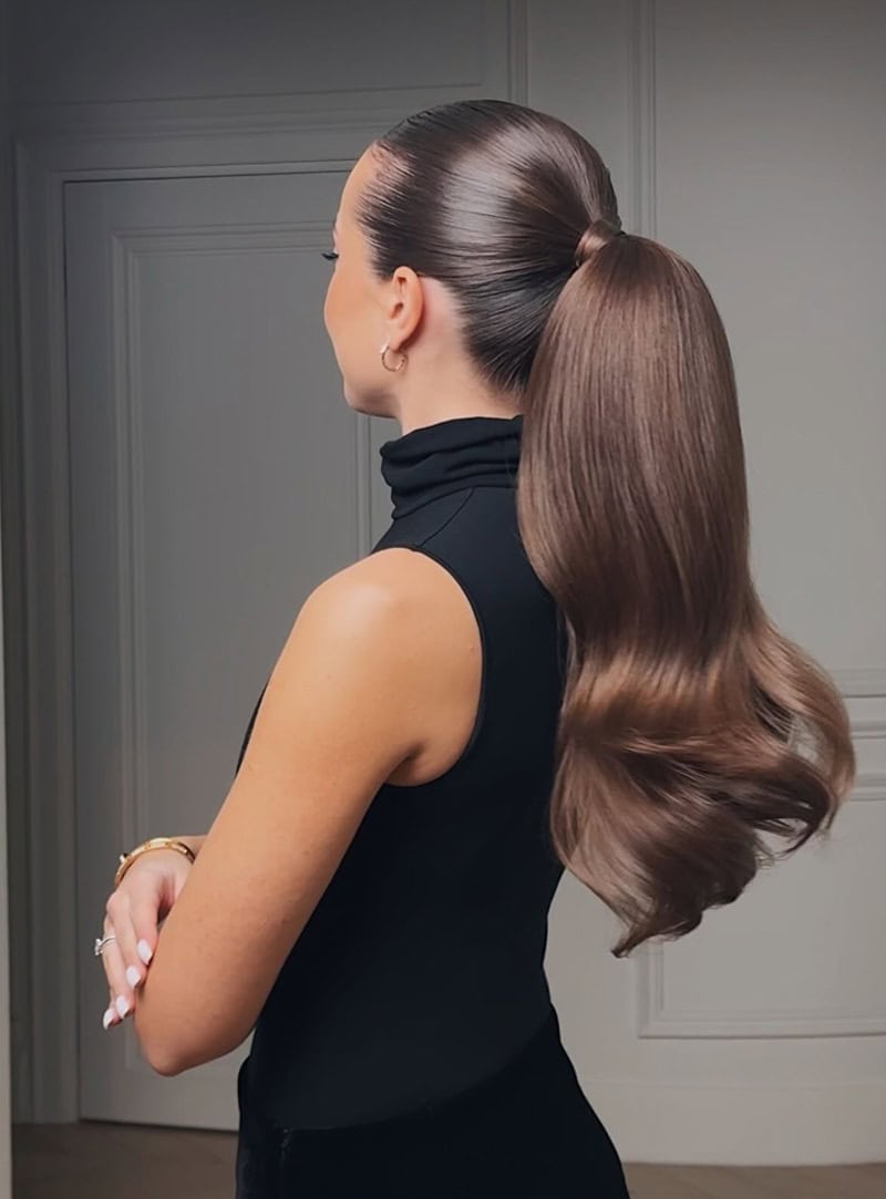 Sleek brunette ponytail with a smooth crown, wrapped base, and wavy tail