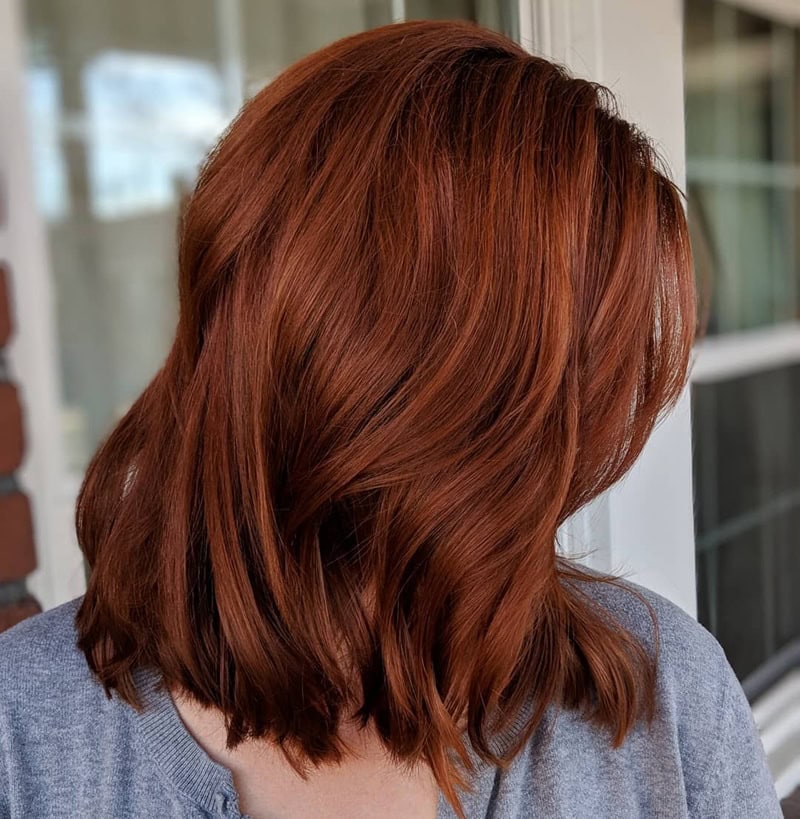 shoulder-length, textured bob in rich reddish-brown auburn shade with loose waves