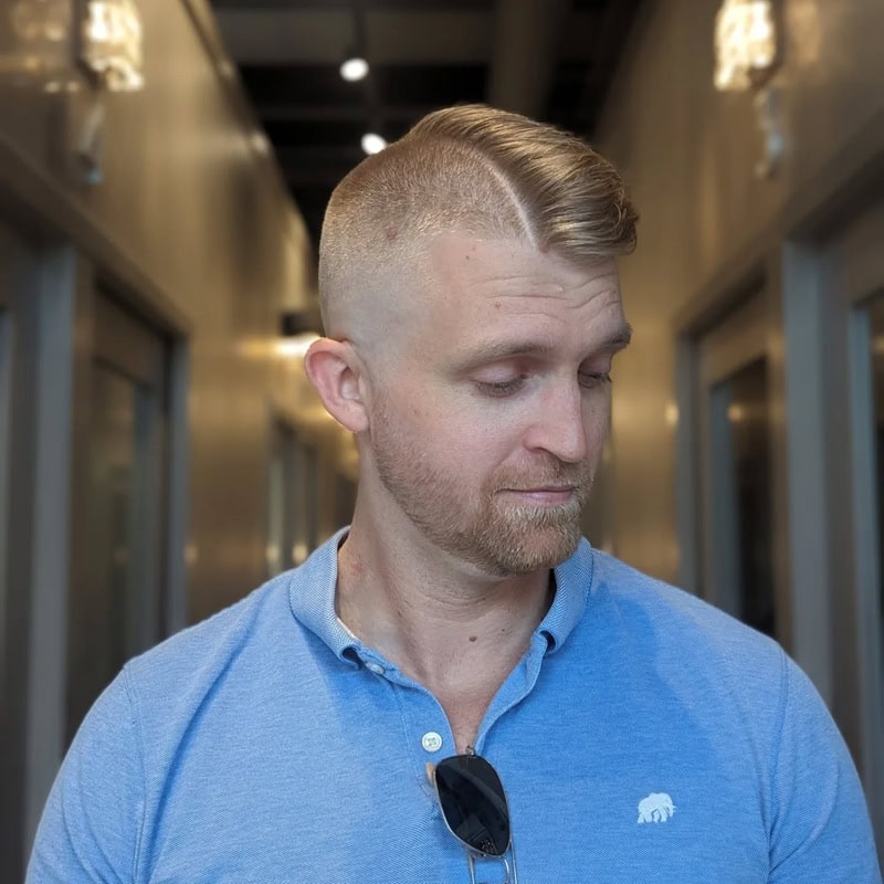blonde man with short side swept hair and hard part