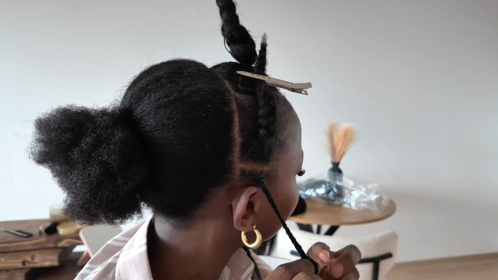 The stylist braids the thin side section with extension added in.