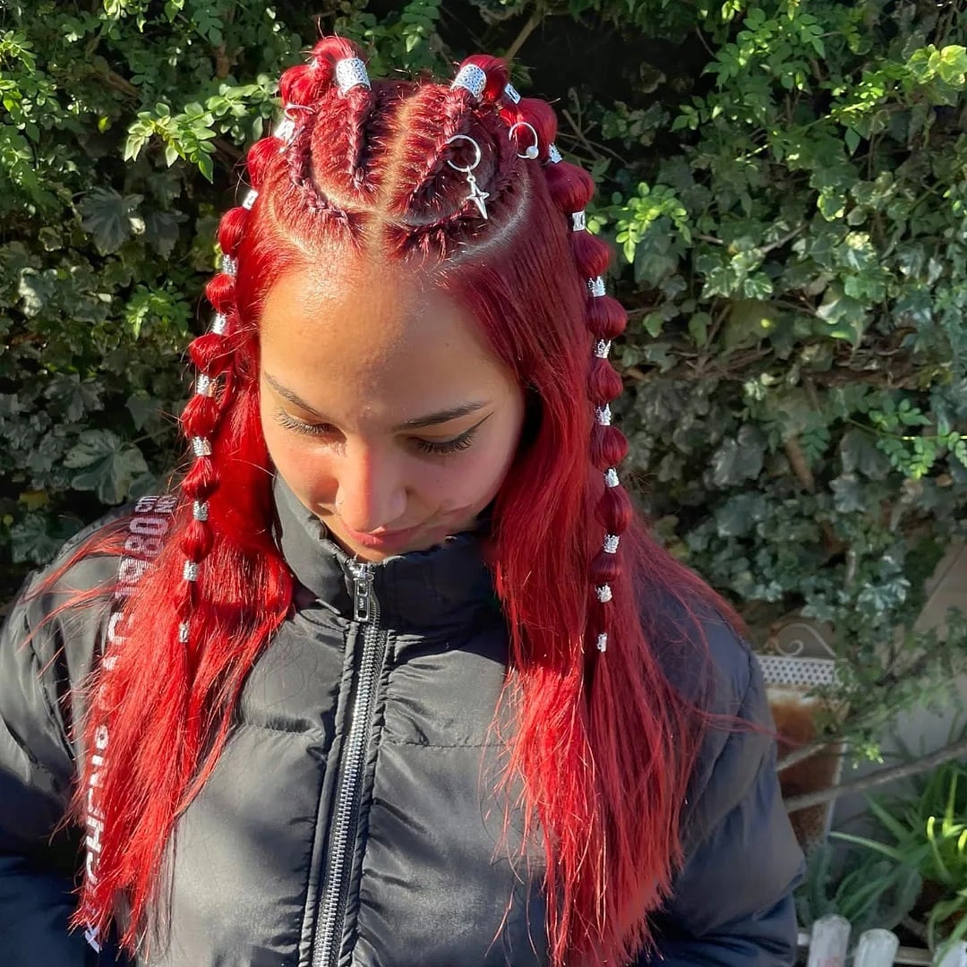 Spanish woman featuring crimson red half-up braided with silver rings