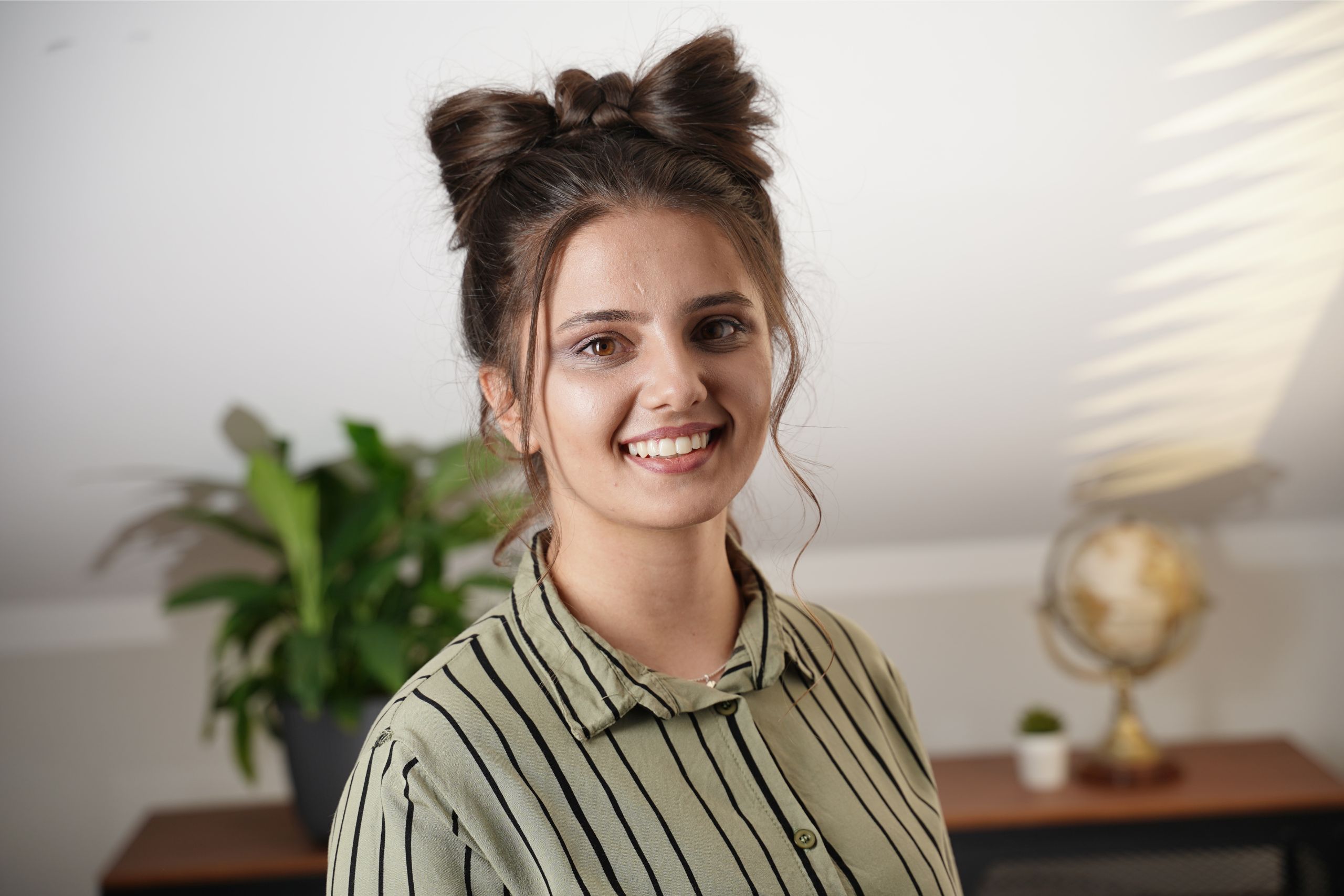 Front view of a woman with a hair bow hairstyle on top of her head and loose face-framing strands.