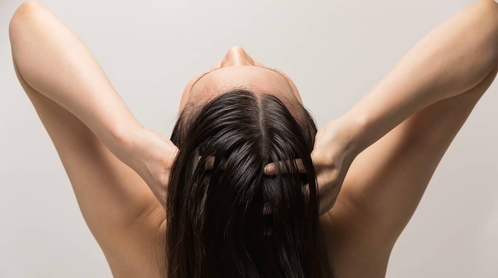 a woman is massaging the scalp