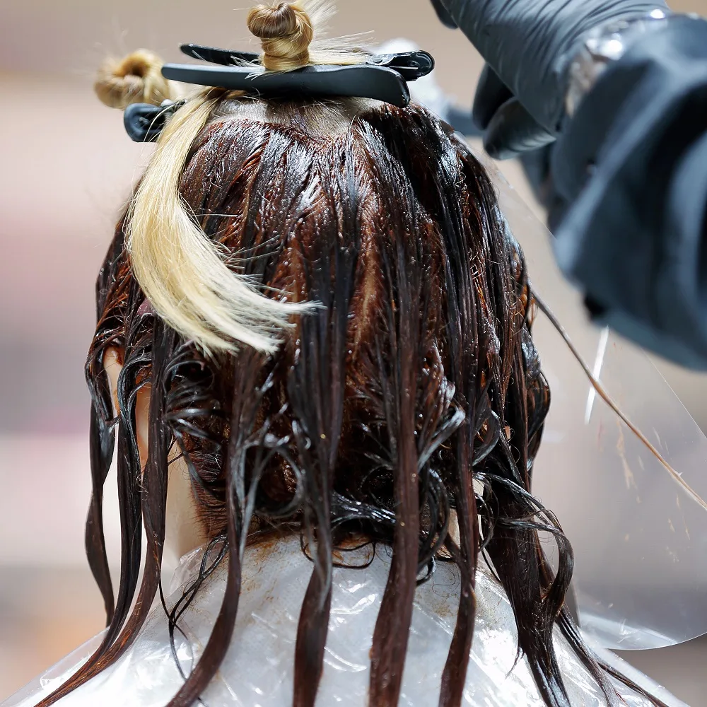 applying brown hair dye over blonde highlights