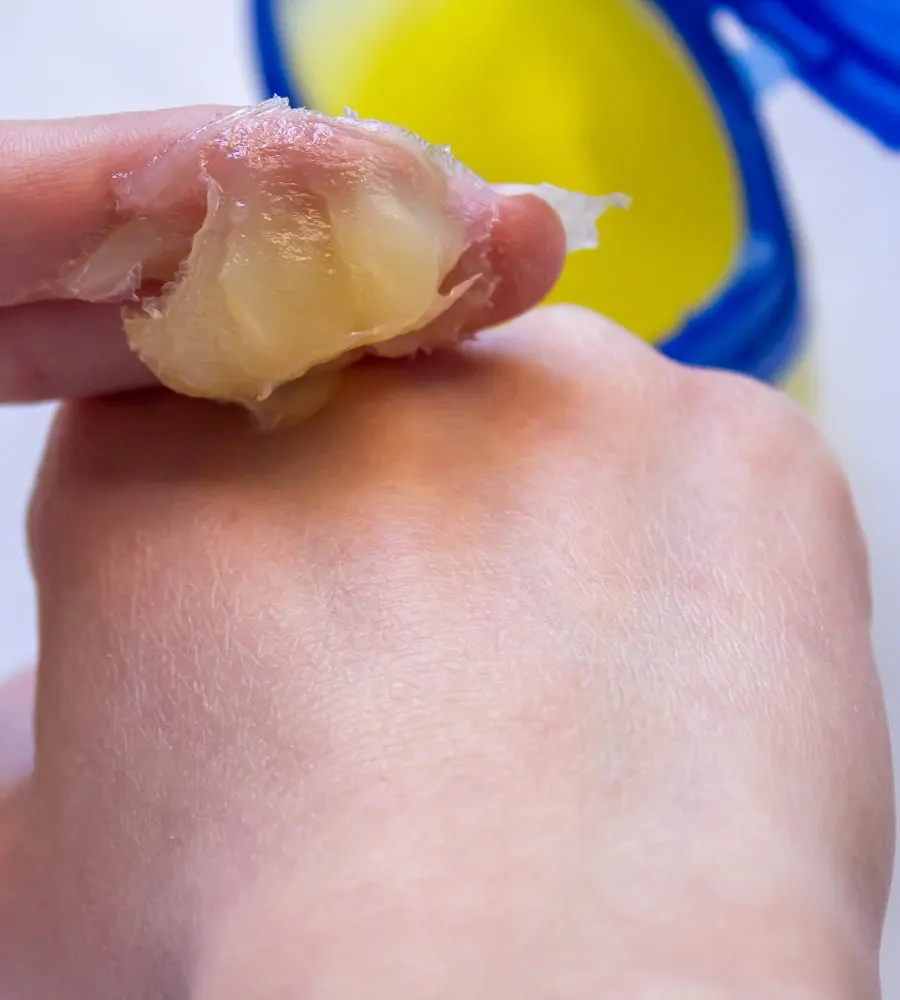 applying petroleum jelly to heal ripped skin from waxing