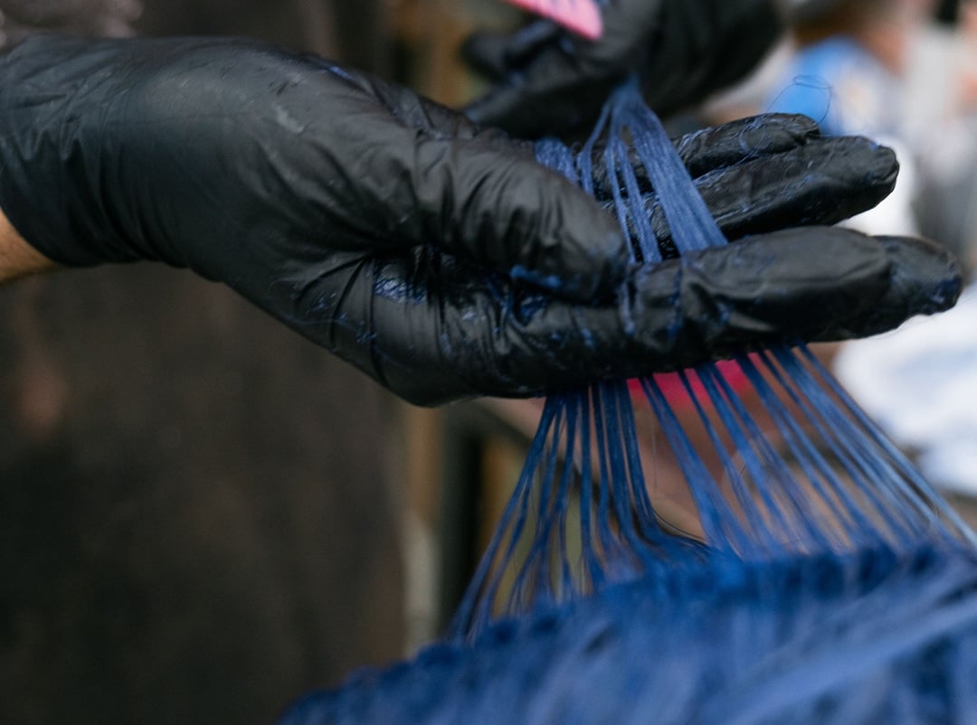 applying semi permanent blue hair dye on black hair strands for a vibrant finish