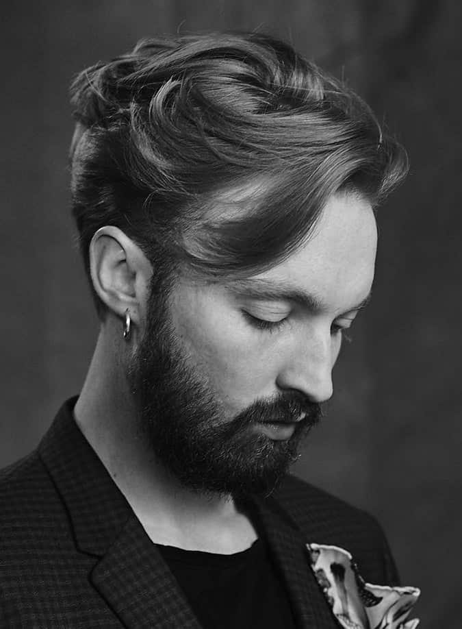 Man with a textured wavy asymmetrical fringe swept over a receding hairline
