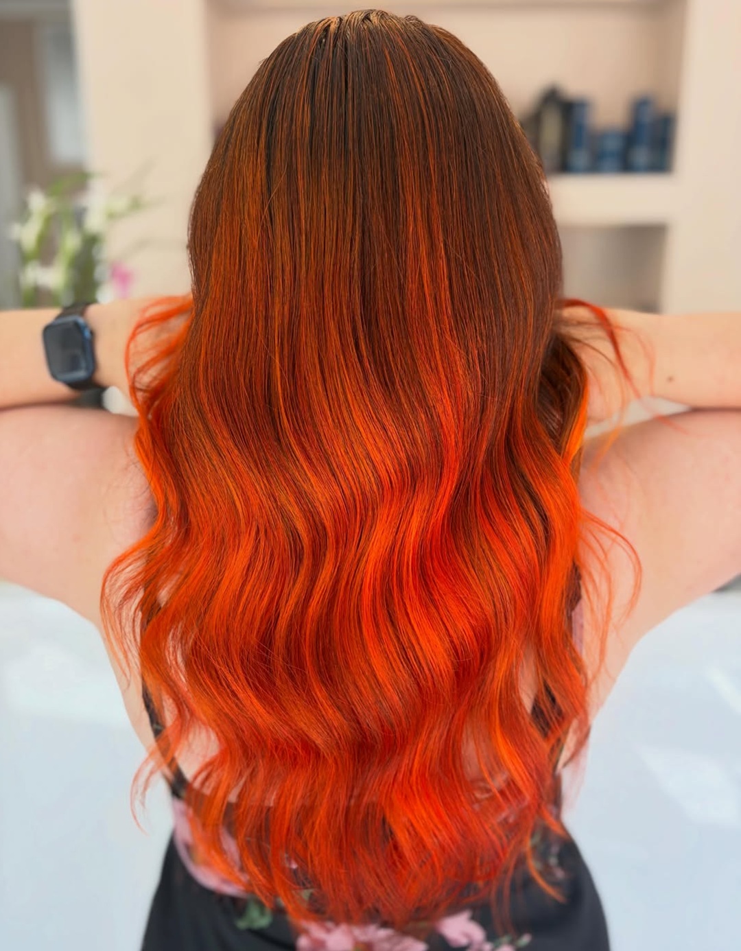 Long wavy hair displaying a rich auburn orange ombre transition
