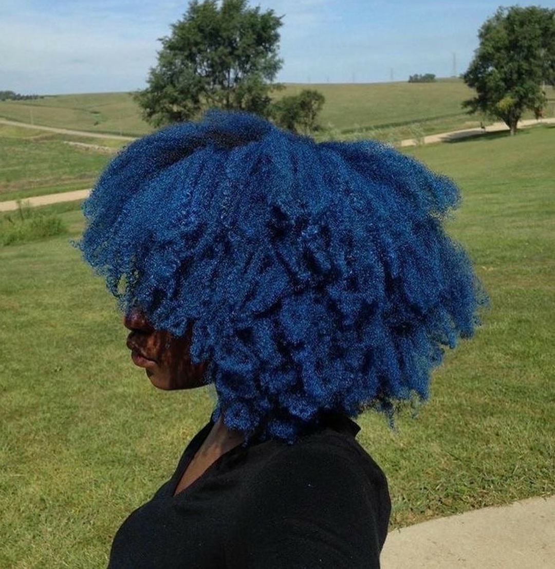 Black girl featuring a voluminous royal blue afro with natural coils