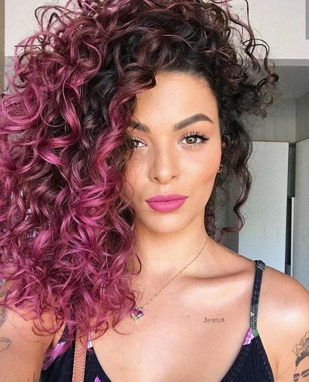 Curly black hair with pink highlights