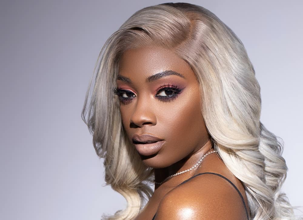 black woman with sew in wavy blonde hairstyle