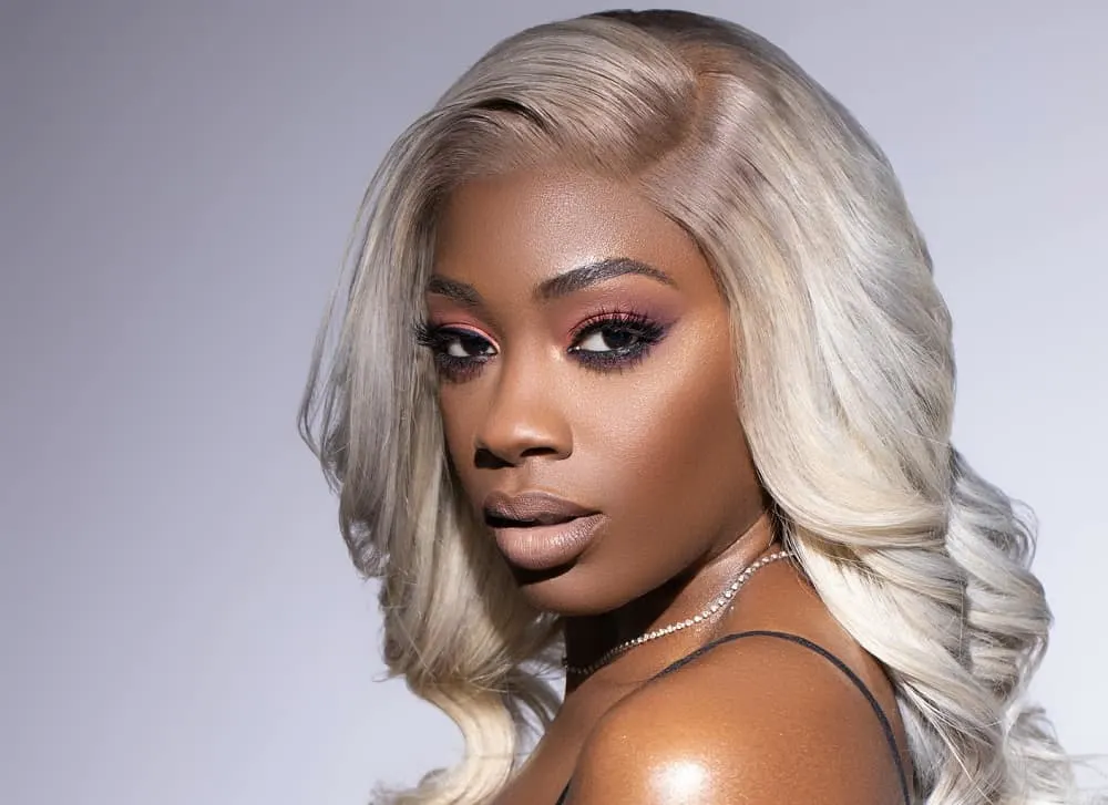 black woman with sew in wavy blonde hairstyle