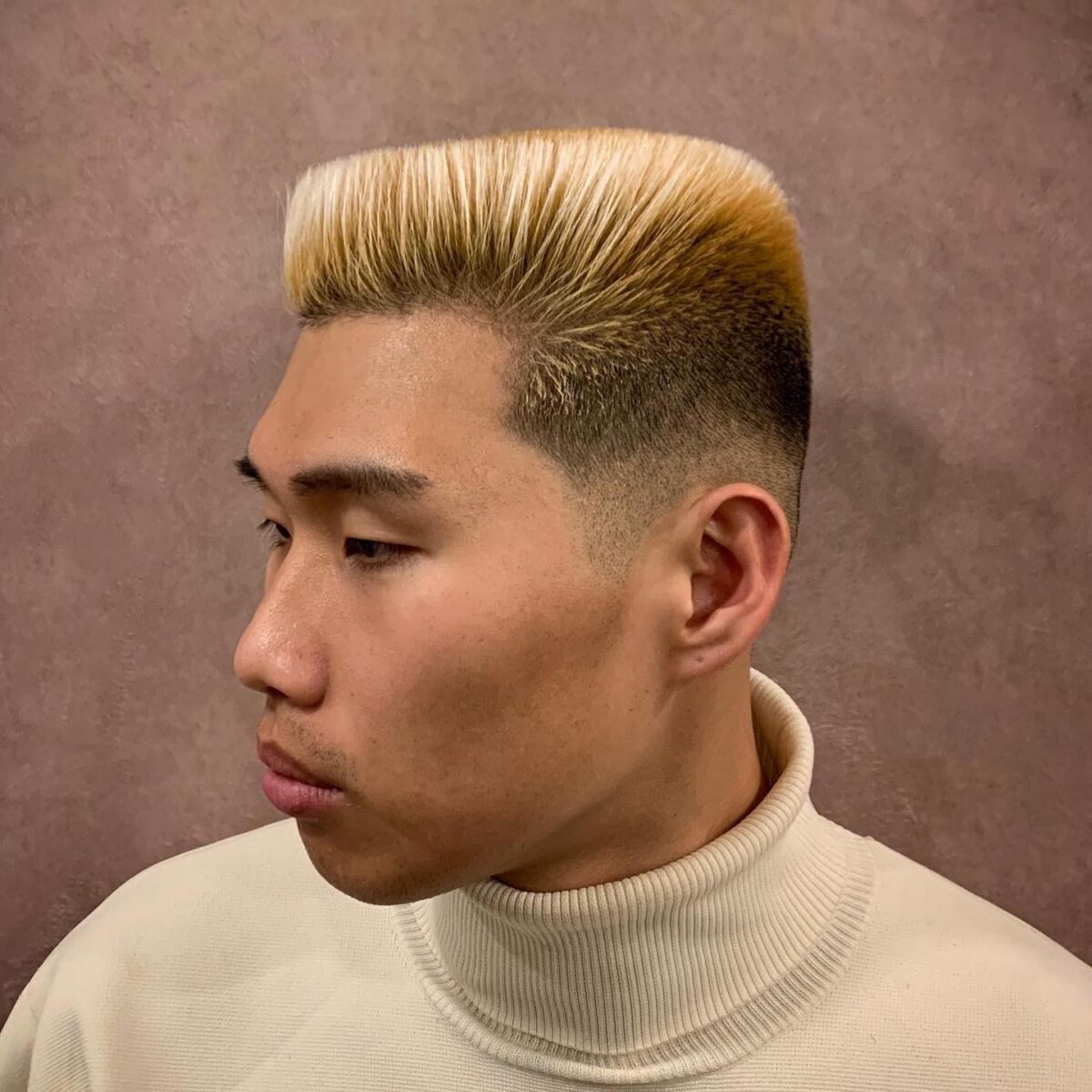 Bleach blonde high flat top haircut with tapered sides