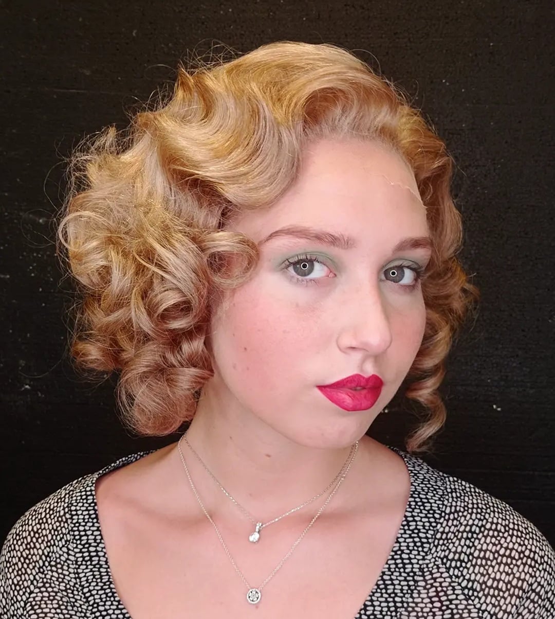Classic 1930s hairstyle featuring golden blonde finger waves and defined pin curls on a short bob haircut