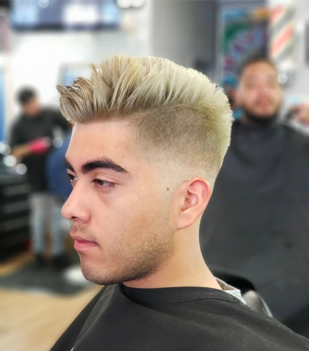 light blonde brushed up hair and a high skin fade