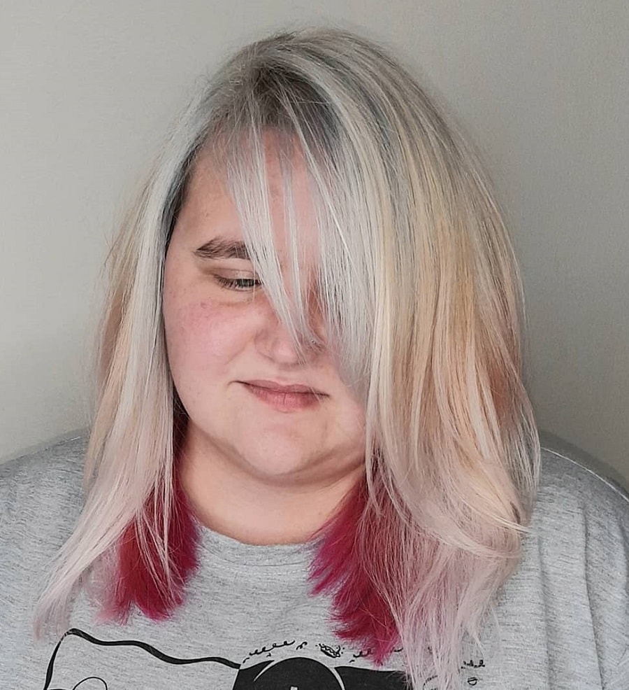 Blonde hair with pink under a round face