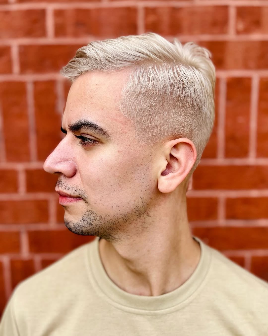 platinum blonde side-swept short haircut with clean faded sides for men