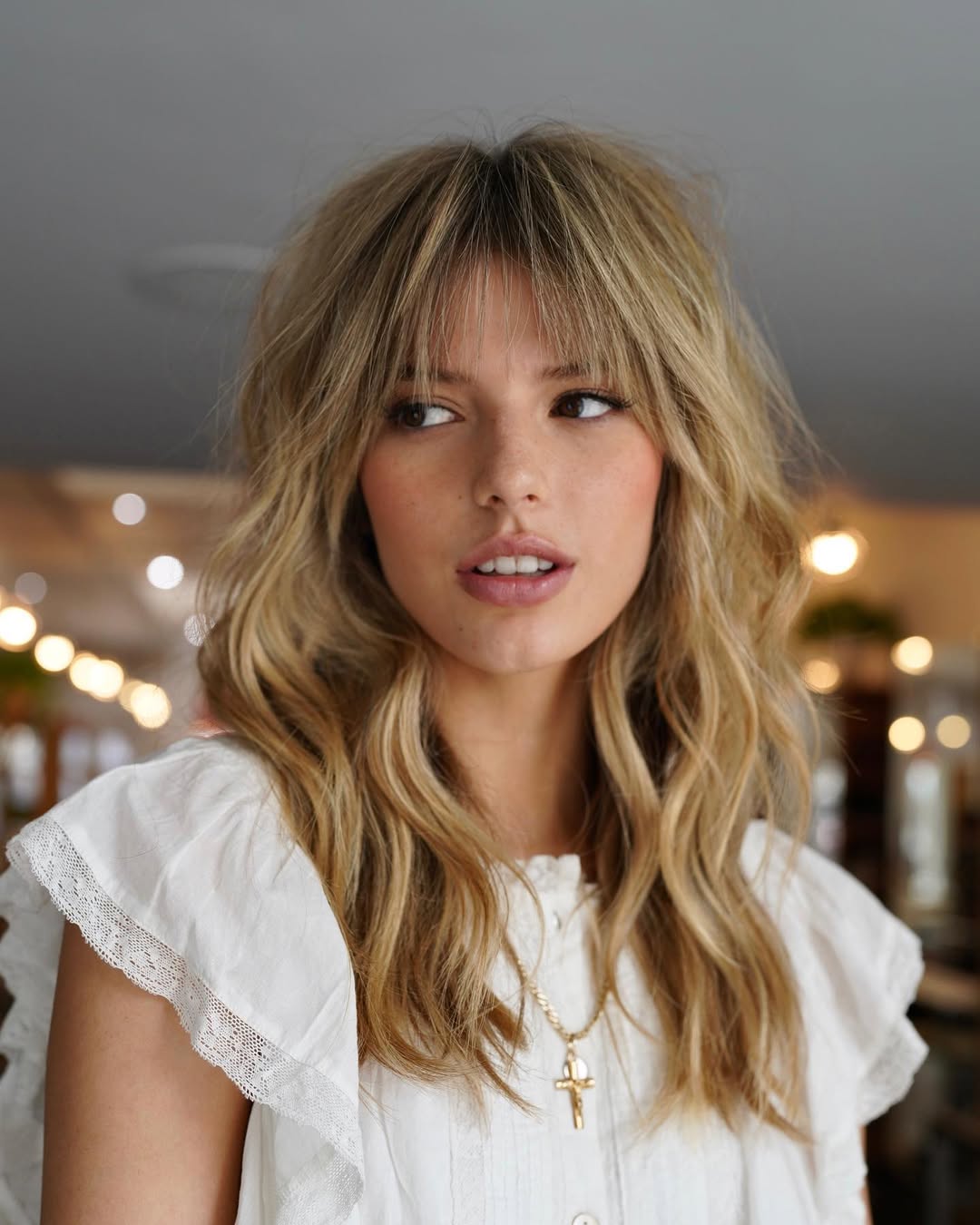 Long wavy blonde haircut with wispy see through bangs