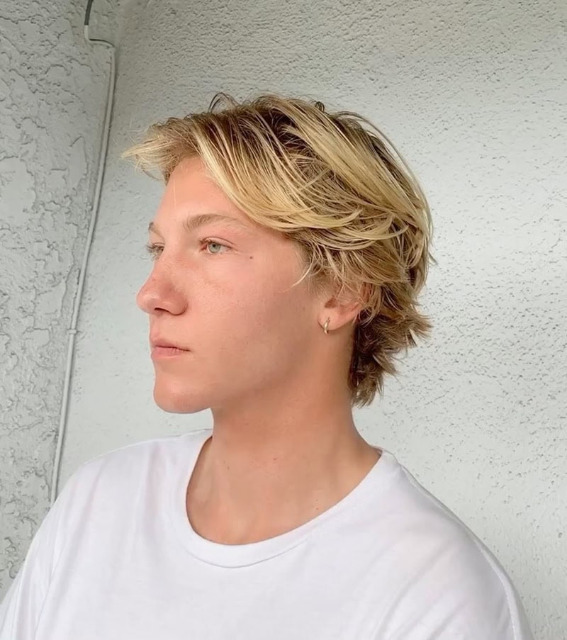 messy, long layered surfer cut with blonde highlights