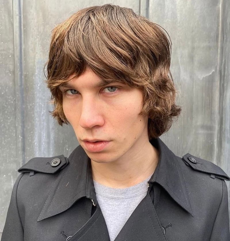Boy with textured brown long layered cut and heavy fringe