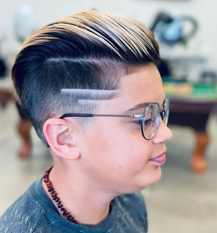 boys slick back hairstyle with design and blonde highlights