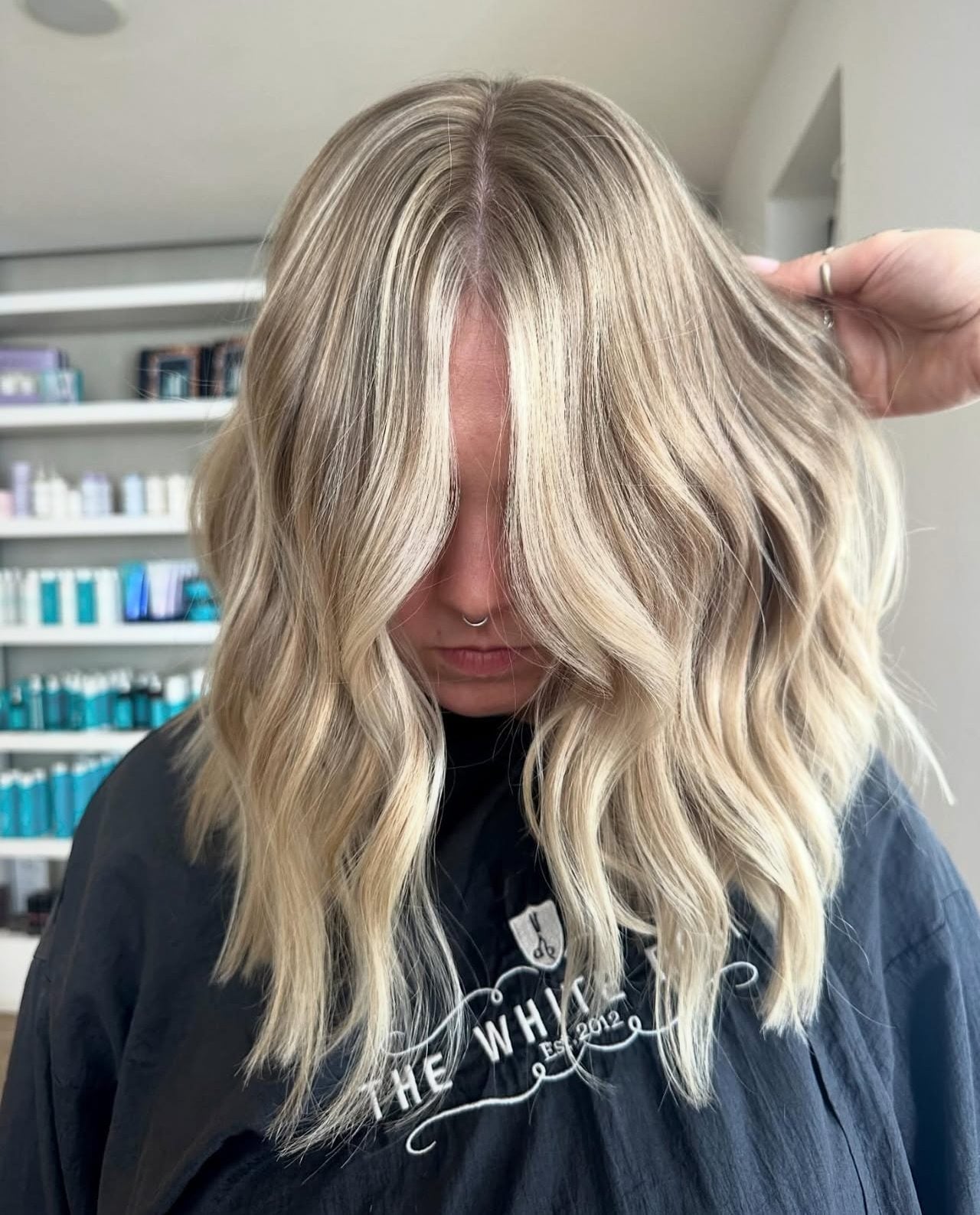 Client with bright, even blonde hair in soft waves, three sessions after arriving with faded brunette box dye