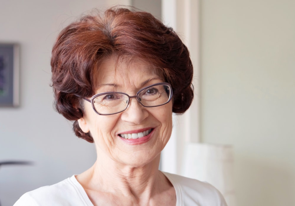 Burgundy pixie cut for older women with glasses