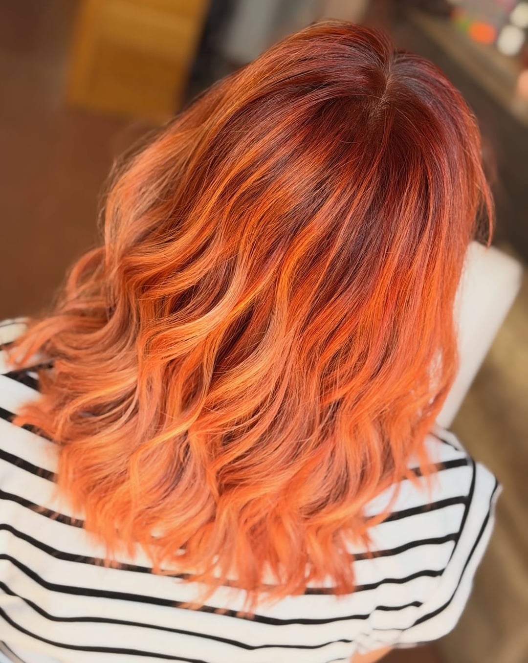 Wavy shoulder-length lob featuring a soft butterscotch orange ombre